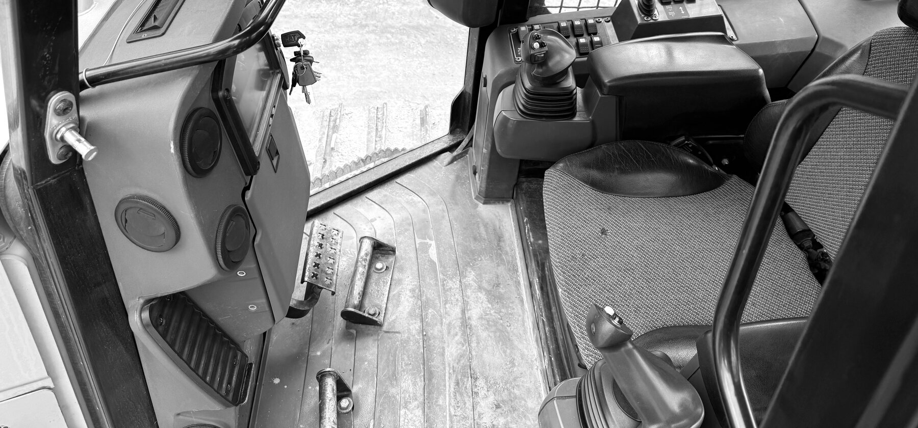 Joystick controls, ignition keys and foot pedals inside a dozer cab