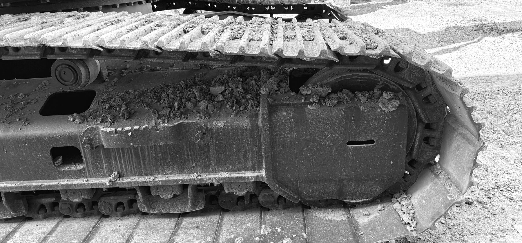 An excavator sprocket and track chain packed with dried ground