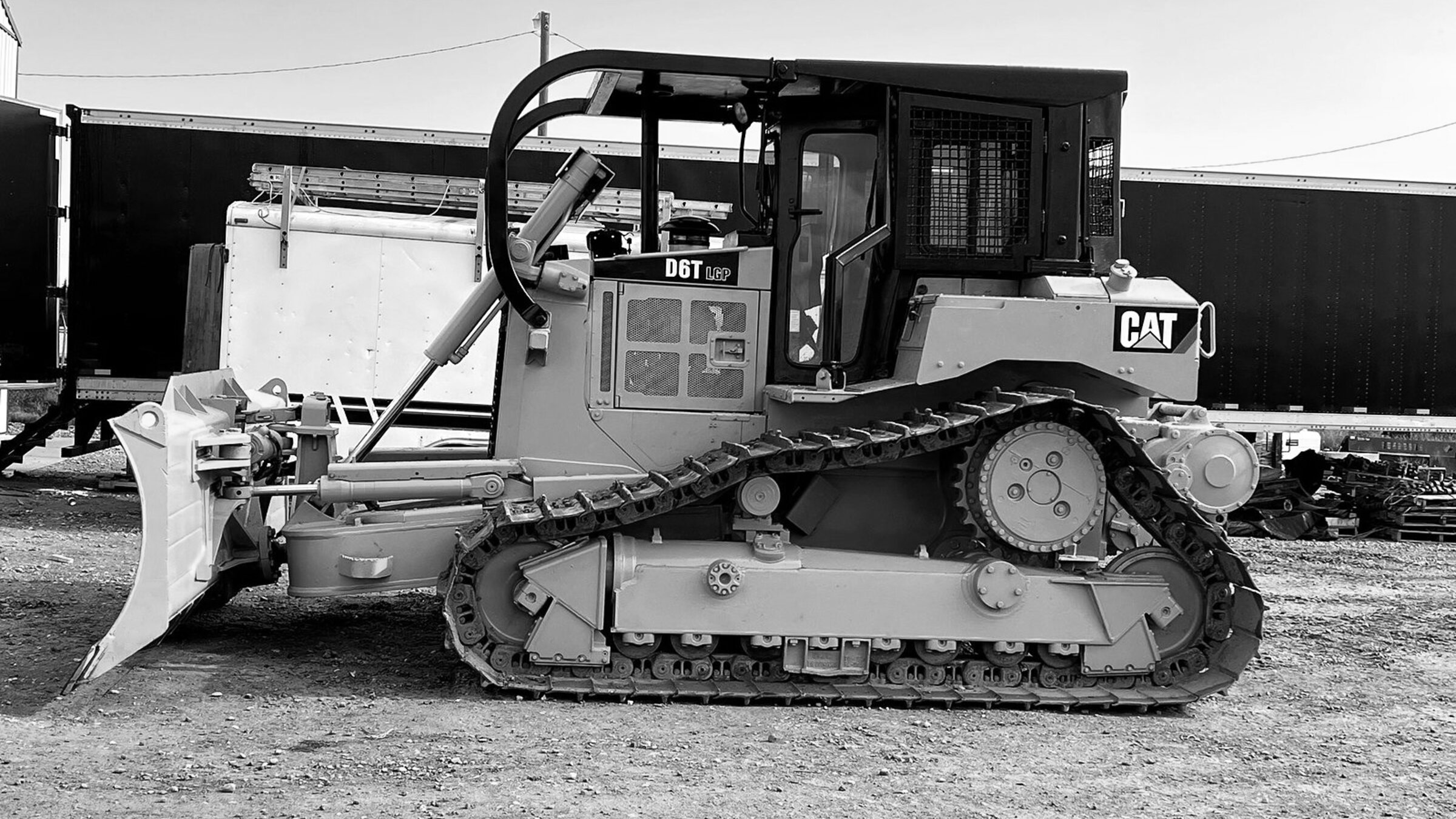 A tracked dozer standing with its blade lowered, engine off
